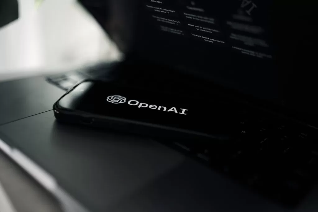 a close up of a laptop on a desk with openai pendrive logo